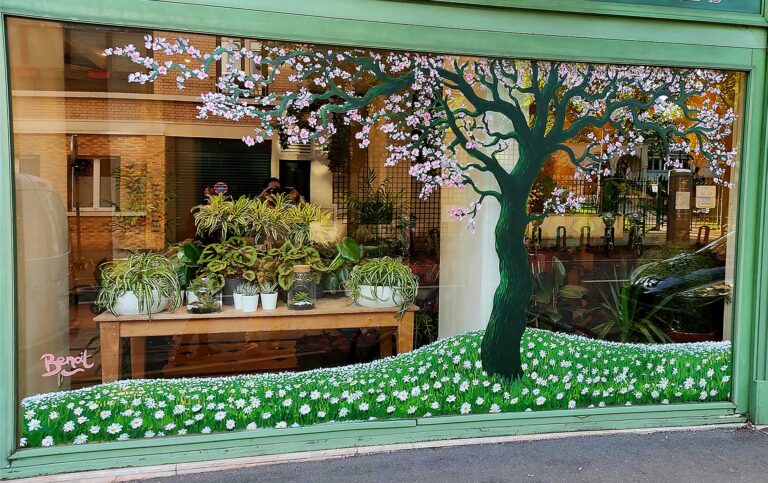 Peinture à la main sur vitrine fleuriste eden flor vanves 2021 La peinture représente cerisier en fleur avec champs de marguerites