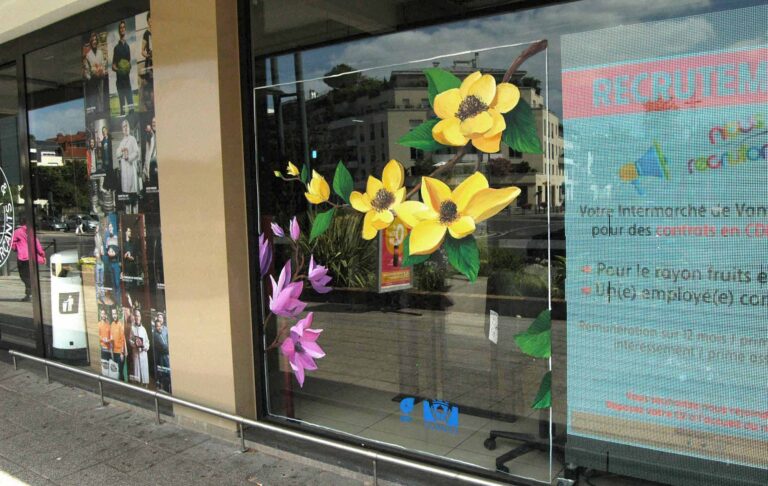 Peinture à la main sur vitrine pour un intermarché représentant des magniolia peint dans un style réaliste.